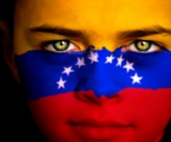 Portrait of a boy with the flag of Venezuela painted on his face