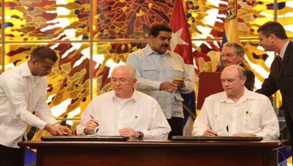 En enero de este año el entonces ministro de Petróleo de Venezuela, Rafael Ramírez, y el ministro de Comercio Exterior de Cuba, Rodrigo Malmierca, renovando el convenio de Cooperación Venezuela-Cuba. (Foto: YVKE)