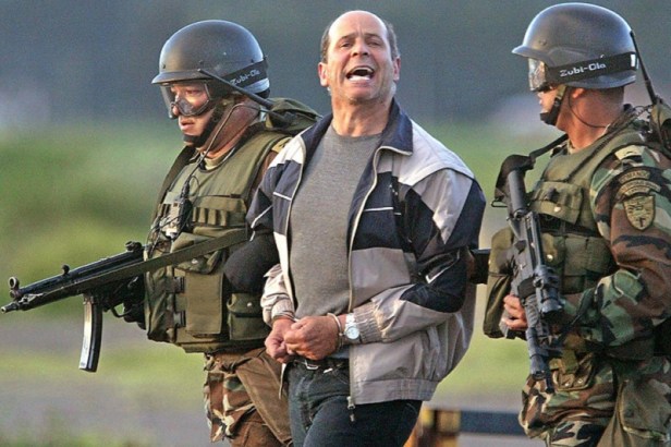 (FILE) Colombian soldiers guard Ricardo Palmera (C), whose nom de guerre is Simon Trinidad, a top rebel leader and former peace negotiator of the Revolutionary Armed Forces of Colombia (FARC, leftist guerrilla), 03 January 2003, upon his arrival to Bogota. The FARC have announced that the arrest of Trinidad, last 02 January in Ecuador, has thwarted negociations between the group, French government representatives and Kofi Annan, Secretary General of the United Nations for the liberation of former presidential candidate Ingrid Betancourt, and other hostages, that has been now put at high risk. AFP PHOTO/Gerardo GOMEZ